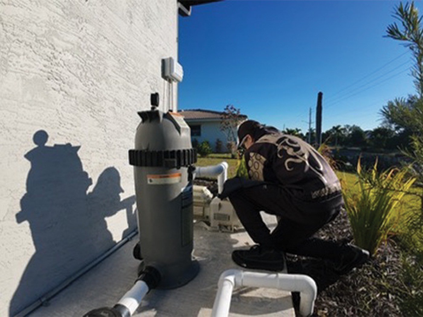 Black Flag technician cleaning a screened lanai pool
